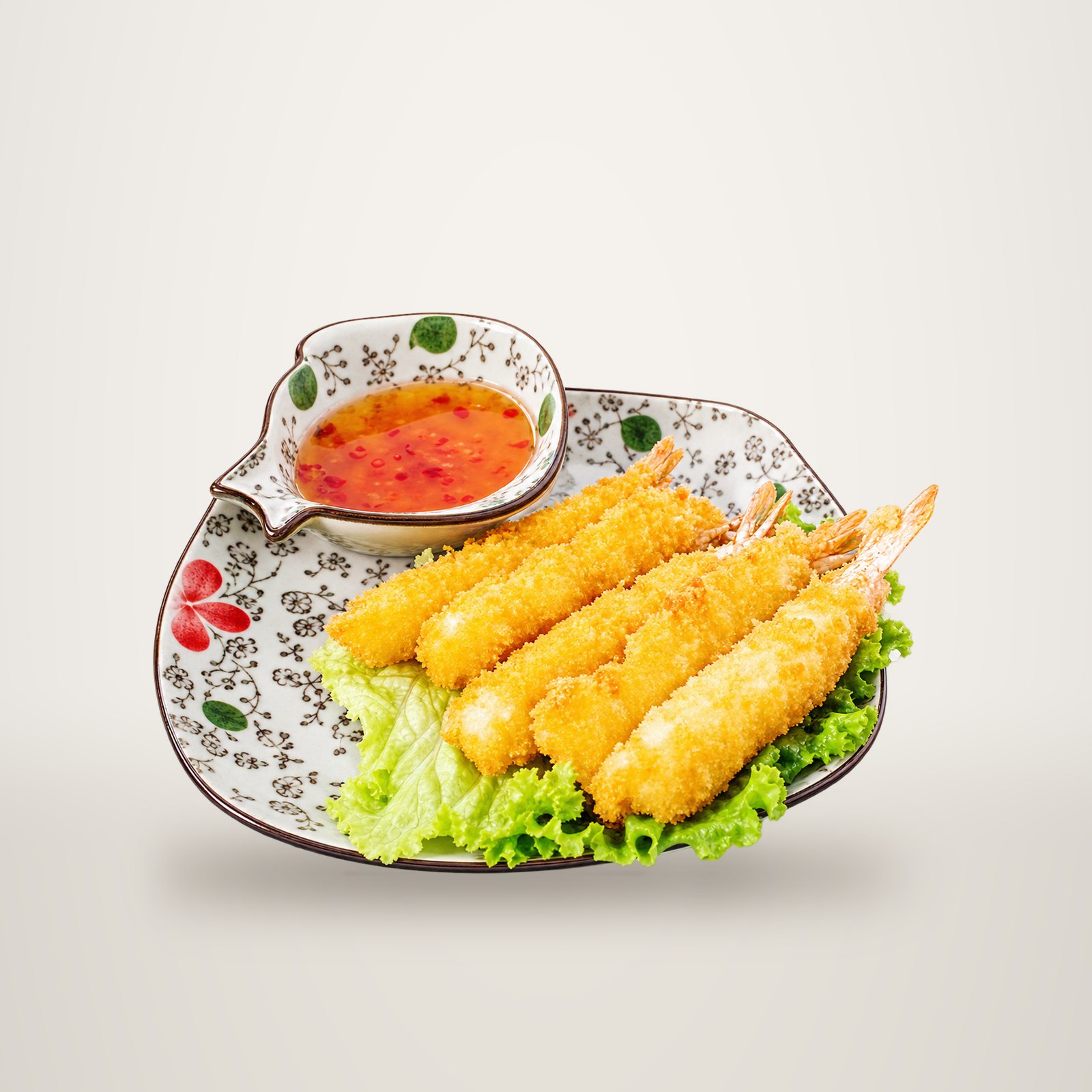 Une assiette décorée présente quatre beignets de crevettes dorés posés sur une feuille de laitue, accompagnés d'un petit bol de sauce aigre-douce.
