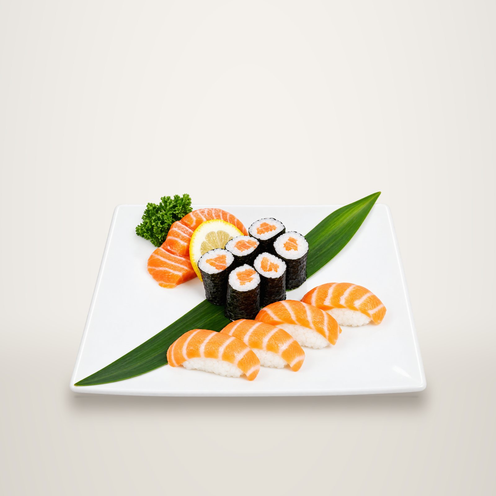 Assiette blanche garnie de nigiris et de makis au saumon, de sashimis, d'une tranche de citron et de persil sur une feuille de bambou verte.