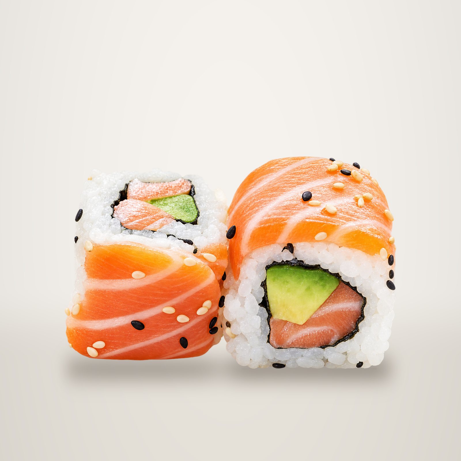 Deux rolls de sushi garnis de fines tranches de saumon, d'avocat et de graines de sésame, présentés sur fond blanc.